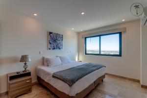 a bedroom with a large bed and a window at Lujoso residencial con amenidades únicas in Mazatlán +19 photos