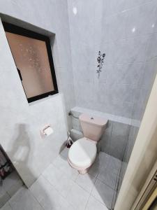 a white bathroom with a toilet and a window at Lovely Paceville Studio E in St Julian's +17 photos