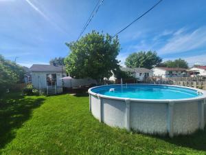 a pool in the yard of a house at Cozy 3-Bedroom Haven, Private Pool & Parking ! in Longueuil