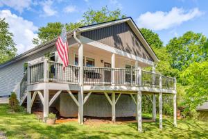 a house with a porch and an american flag at Walk to Dtwn Waynesville Home with Deck! in Waynesville