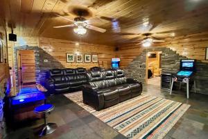 een woonkamer met een leren bank en een stenen muur bij Hidden Haven by Venture Smoky Mountains in Gatlinburg