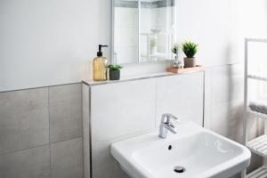 a white bathroom with a sink and a mirror at Flussblick am Töpferberg 5 in Bad Schwartau +24 photos