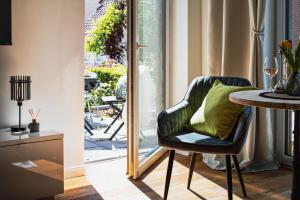 a dining room with a table and a chair with a green pillow at Flussblick am Töpferberg 5 in Bad Schwartau