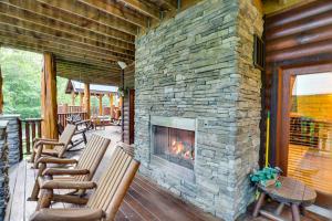 een stenen open haard op een veranda met schommelstoelen bij Hidden Haven by Venture Smoky Mountains in Gatlinburg