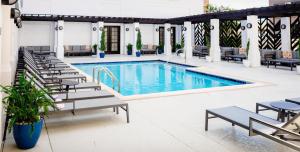 a pool with chaise lounge chairs and a hotel at The Chifley Houston, Tapestry Collection by Hilton in Houston +40 photos