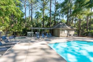 ein Swimmingpool mit Stühlen und einem Pavillon in der Unterkunft 1016 Sparrow Pond Cottage by Akers Ellis Rentals in Kiawah Island