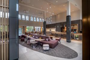 波茨坦Hampton By Hilton Potsdam Babelsberg的大楼内设有沙发和桌子的大厅