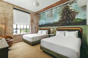 门罗The Hotel Monroe, Tapestry Collection By Hilton的一间有两张床的房间，墙上挂着一幅画 更多22张照片
