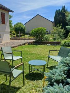 a group of chairs and a table in the grass at La maison des doux souvenirs in Les Riceys