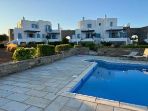 una villa con piscina frente a una casa en Sea View Serenity Paros, en Ampelas