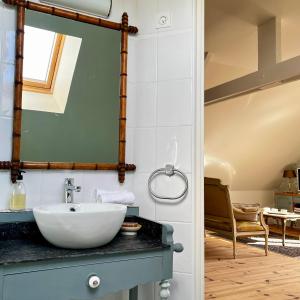 a bathroom with a sink and a mirror at La Maison de la Hulotte in Golleville +43 photos