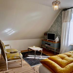 a living room with a couch and a tv at La Maison de la Hulotte in Golleville