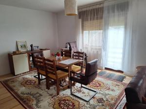a living room with a dining room table and chairs at Relax Rose Apartment in Kulen Vakuf