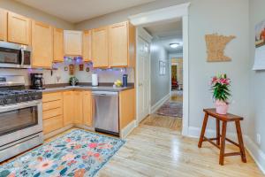 a kitchen with wooden cabinets and a rug on the floor at Less Than 1 Mi to Xcel Energy Center Walkable Hideaway! in Saint Paul