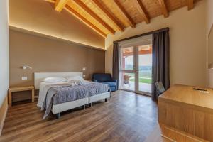 a bedroom with a bed and a large window at B&B Ca' Marognole in Caprino Veronese