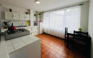 a kitchen with a window and a table and a stove at Basilica Apartment 3 Bed 2 Bath in Baños