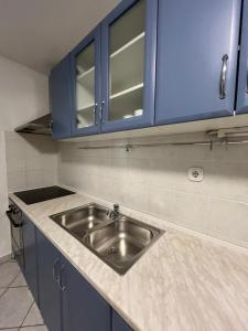 a kitchen with a sink and blue cabinets at Apartman Jugo in Kaštela +6 photos
