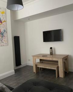 sala de estar con mesa y TV de pantalla plana en Apex Living NE - Beachville House II, en Sunderland