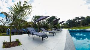 a group of chairs and umbrellas next to a swimming pool at Siyabonga Boutique Lodge in Nelspruit +24 photos