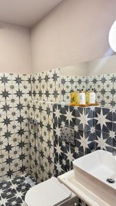 a bathroom with black and white tiles and a sink at Levanta apartment in Asprovalta