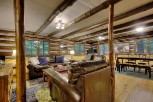 a living room with a leather couch and a table at Waterfalls Edge by Venture Smoky Mountains in Pigeon Forge