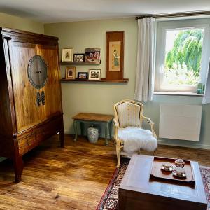 a living room with a chair and a table at La Maison de la Hulotte in Golleville