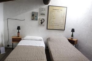 two beds in a room with two lamps and a poster on the wall at Pub house in Lucca