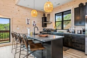a kitchen with wooden walls and a large island with bar stools at Velvet Monkey Retreat in Sevierville
