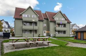 a picnic table in front of a large house at Comfortable and Renovated Apartment - Sunny balcony, Central, Free parking in Haugesund