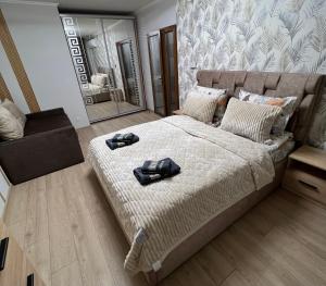 a bedroom with a bed with two shoes on it at Однокімнатна квартира in Chernivtsi