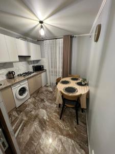 a small kitchen with a table and a stove at Однокімнатна квартира in Chernivtsi
