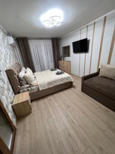 a bedroom with a bed and a couch at Однокімнатна квартира in Chernivtsi