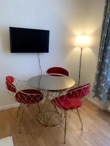 a room with a table and two chairs and a television at Appartement Confort - Puteaux La Défense in Puteaux