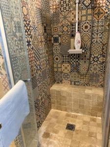 a bathroom with a shower with a tiled wall at Appartement Confort - Puteaux La Défense in Puteaux +5 photos