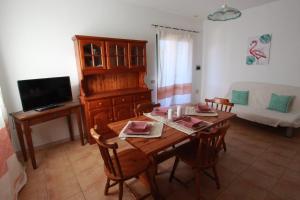 サン・テオドーロにあるResidence La Funtanaの木製のテーブルと椅子のあるリビングルーム