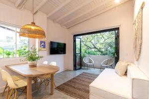 a living room with a table and chairs and a tv at Apartamentos Primavera Manila by HOUSY HOST in Medellín