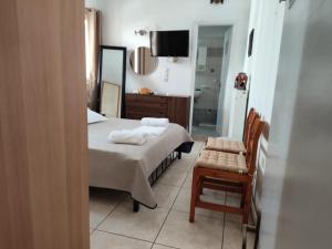 a bedroom with a bed and a chair and a mirror at Nikolettas Apartments in Faros