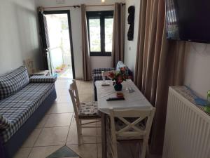a living room with a table and a couch at Nikolettas Apartments in Faros