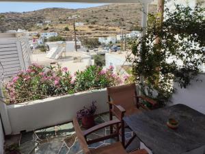 a balcony with a table and chairs and a view of a city at Nikolettas Apartments in Faros