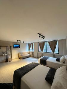 a large bedroom with two beds and a couch at Hotel Coral Boutique in Medellín