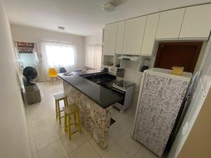 a kitchen with white cabinets and a black counter top at Apartamento Baixu 2 in Prado