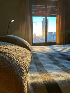 a bedroom with a bed and a window with a view at Departamento con Balcón y Asador in Río Cuarto