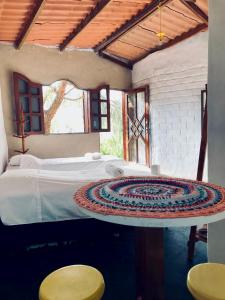 a bedroom with a bed and two stools at Espaço Shanti - Chalés in Sao Jorge