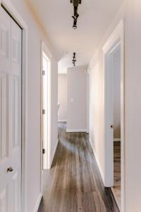 an empty hallway with white walls and wood floors at 4-bedroom Burlington with AC & Wifi in Burlington