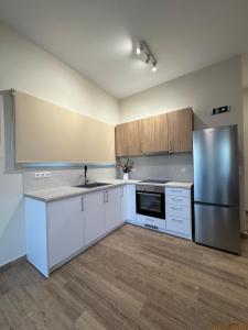 a kitchen with white cabinets and a stainless steel refrigerator at Margarita House in Moraitika