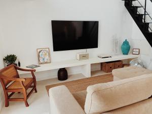 a living room with a tv on a white wall at Lusterra Grounds in Amarante