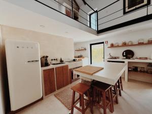 a kitchen with a white refrigerator and a table at Lusterra Grounds in Amarante