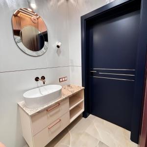 a bathroom with a sink and a mirror at Pratum Pink&Blue Mikołajki Apartament Maria Antonina z ogródkiem i tarasem in Mikołajki