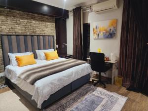 a bedroom with a bed with yellow pillows and a desk at The Green leaf Executive Home in Pretoria