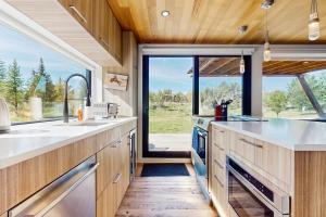 a kitchen with wooden cabinets and a large window at Tree Farm Sanctuary in Basalt +33 photos